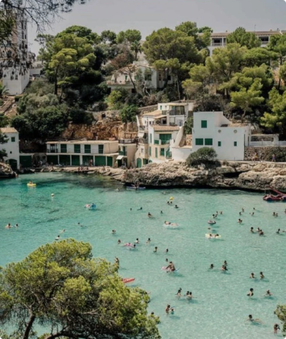 People in the ocean with a view of a Mallorca Property